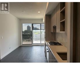 A modern kitchen with a stove top oven and a view of the city.