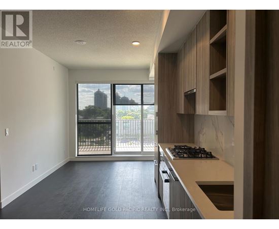 A modern kitchen with a stove top oven and a view of the city.