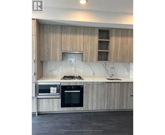 A kitchen with wooden cabinets and a marble backsplash.