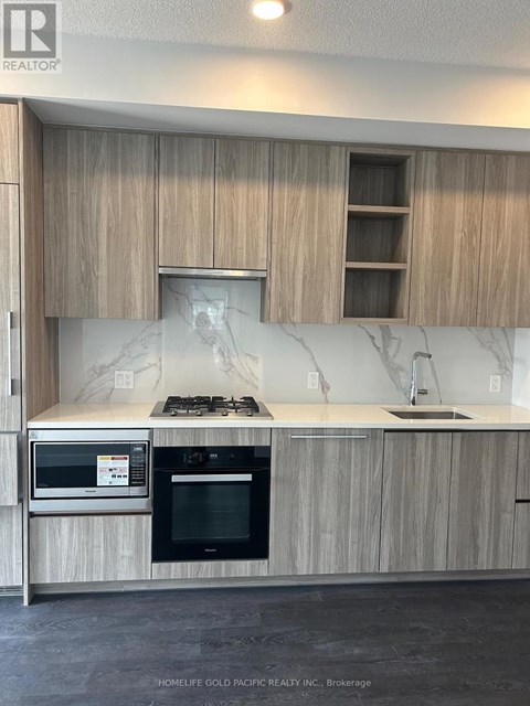 A kitchen with wooden cabinets and a marble backsplash.