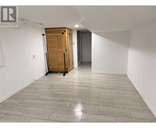 A room with a wooden cabinet and a grey floor.