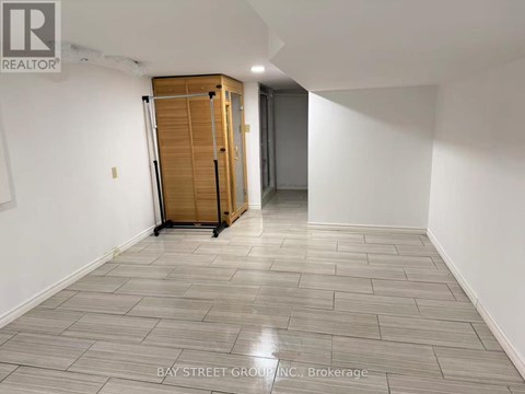 A room with a wooden cabinet and a grey floor.
