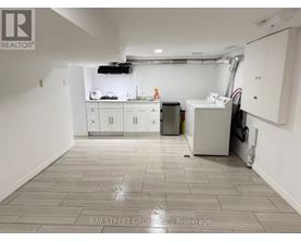 A clean, empty room with white cabinets and a tiled floor.