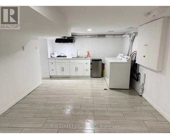 A clean, empty room with white cabinets and a tiled floor.