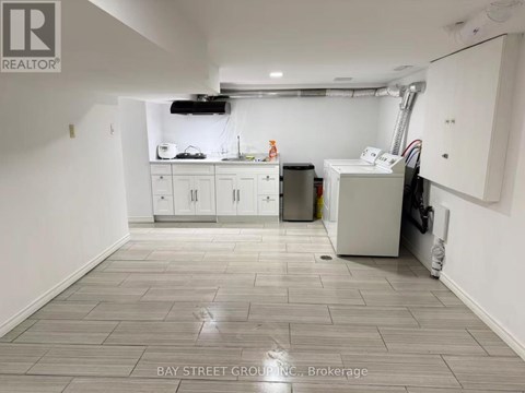 A clean, empty room with white cabinets and a tiled floor.