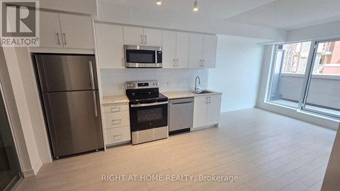 A modern kitchen with stainless steel appliances and white cabinets.