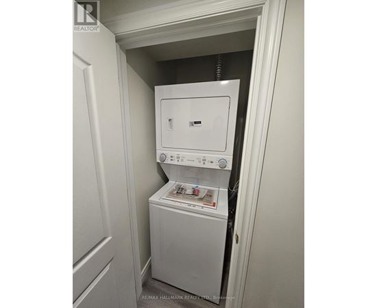 A white dryer and washer are in a small closet.