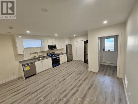 A spacious kitchen with white cabinets and a microwave.