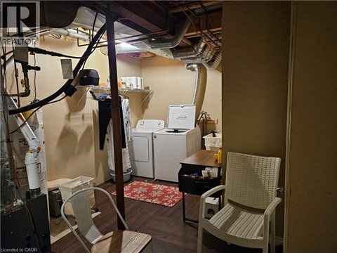 A room with a chair, a table, and a washing machine.