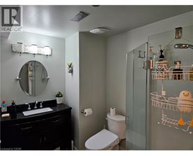 A bathroom with a toilet, sink, and mirror.