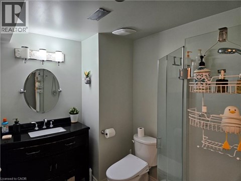 A bathroom with a toilet, sink, and mirror.