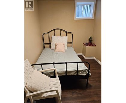 A bedroom with a bed, chair, and small table.