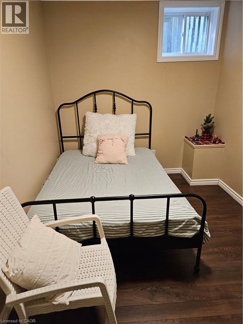 A bedroom with a bed, chair, and small table.
