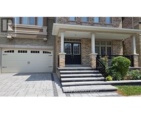 A house with a black front door and a stone pillar.