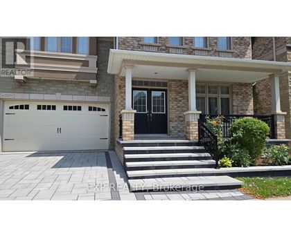 A house with a black front door and a stone pillar.