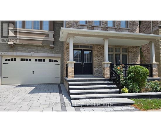 A house with a black front door and a stone pillar.