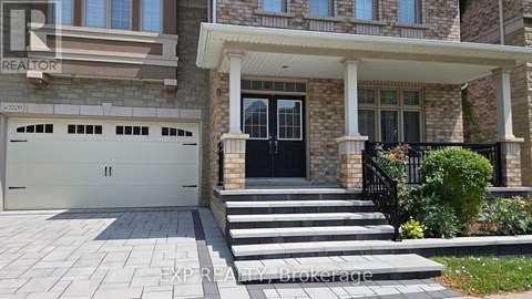 A house with a black front door and a stone pillar.