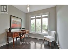 A room with a desk, chair, and a painting on the wall.