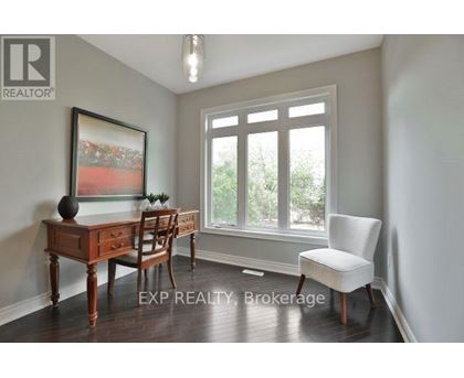 A room with a desk, chair, and a painting on the wall.
