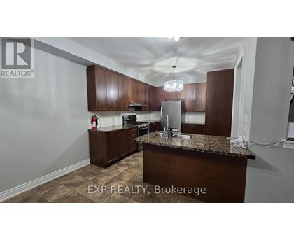 A kitchen with brown cabinets and a granite countertop.
