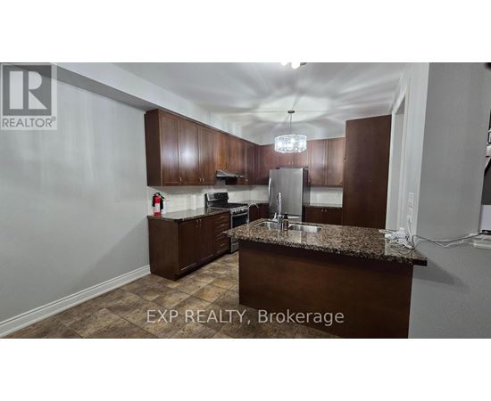 A kitchen with brown cabinets and a granite countertop.