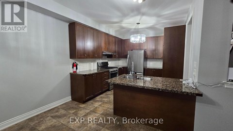 A kitchen with brown cabinets and a granite countertop.