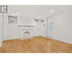 A white room with a fireplace and wooden flooring.