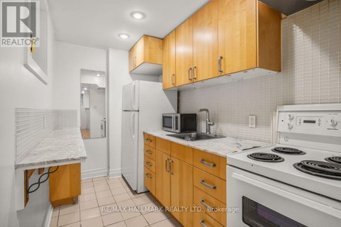 A kitchen with wooden cabinets and white appliances.