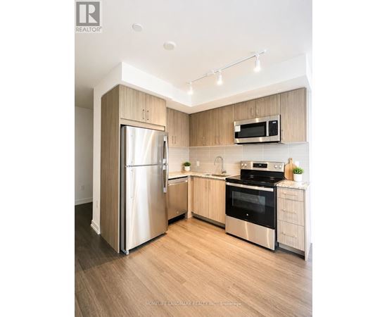 A modern kitchen with wooden cabinets and stainless steel appliances.
