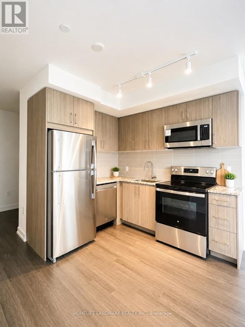 A modern kitchen with wooden cabinets and stainless steel appliances.