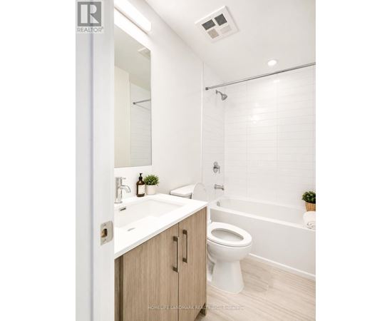 A white bathroom with a toilet, sink, and bathtub.