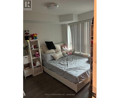 A bedroom with a bed, nightstand, and shelves.