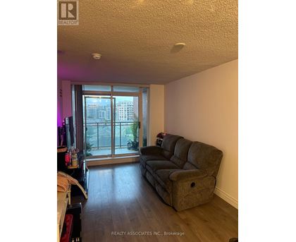 A living room with a grey couch and a sliding glass door.