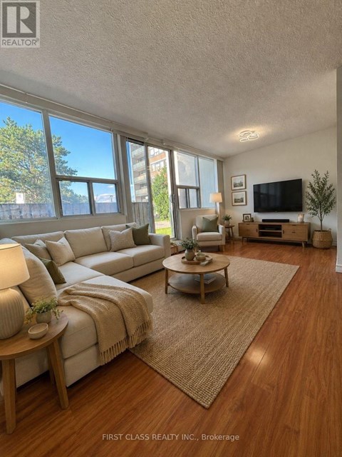 A well-lit living room with a large couch and a flat-screen TV.