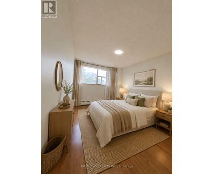 A bedroom with a large bed, a wooden nightstand, and a wicker basket on the floor.