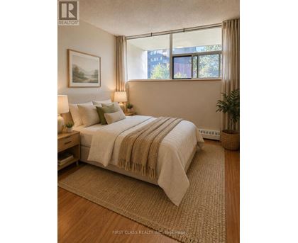 A bedroom with a large bed and a painting on the wall.