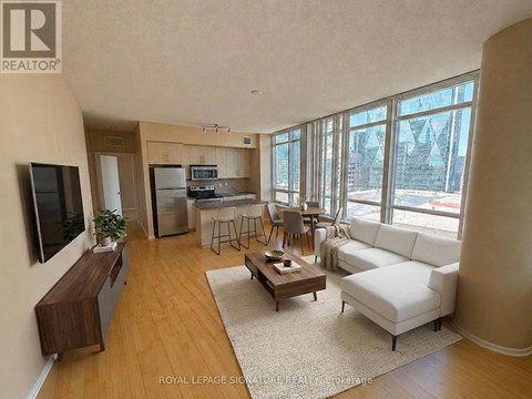 A living room with a white couch and a wooden floor.
