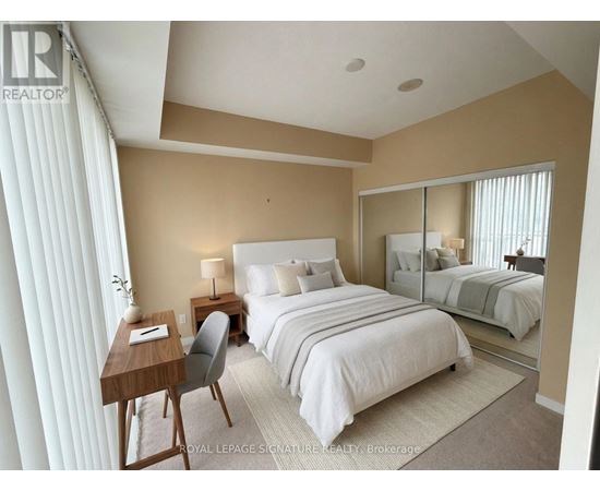 A bedroom with a large bed, a desk with a chair, and a mirror on the wall.