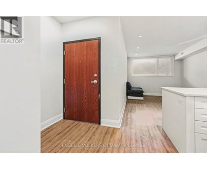 A room with a wooden floor and a brown door.