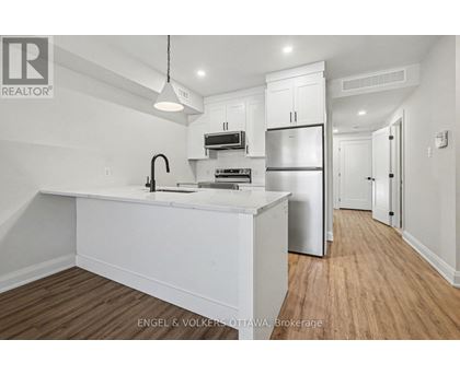 A modern kitchen with white cabinets and stainless steel appliances.