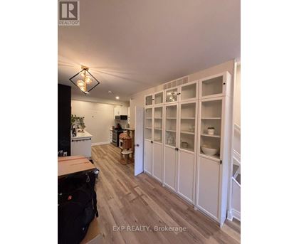 A kitchen with white cabinets and a black fridge.