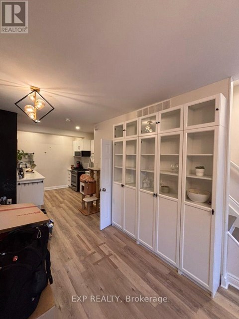 A kitchen with white cabinets and a black fridge.