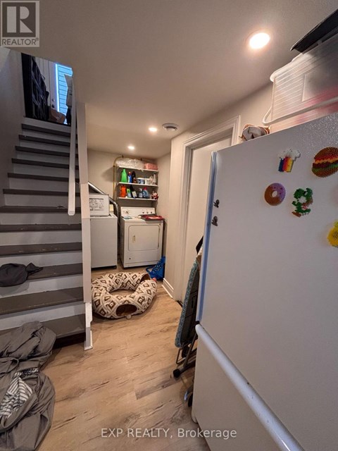 A white refrigerator with magnets and a door open in a kitchen.