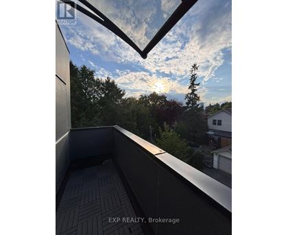 A balcony with a view of the sky and trees.