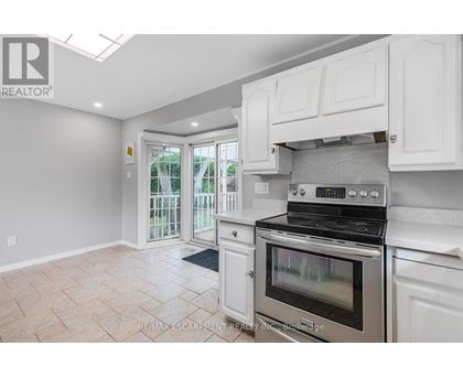 A kitchen with white cabinets and a stainless steel oven.