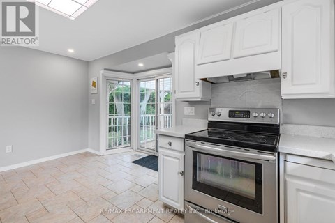 A kitchen with white cabinets and a stainless steel oven.