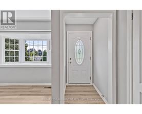 A white door with a glass window is in a room with white walls.
