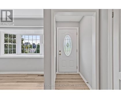 A white door with a glass window is in a room with white walls.