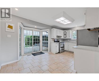 A kitchen with white cabinets and a tiled floor.