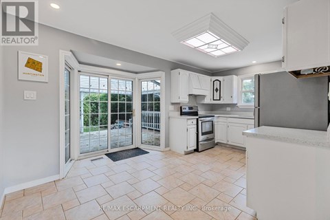 A kitchen with white cabinets and a tiled floor.